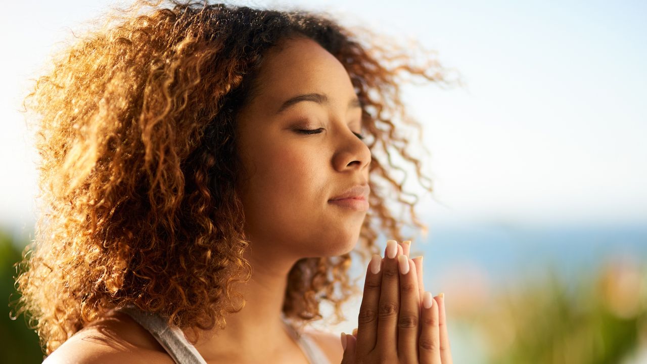 woman praying with eyes closed