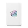 white hardcover notebook with Your Heart Is Calling logo on front